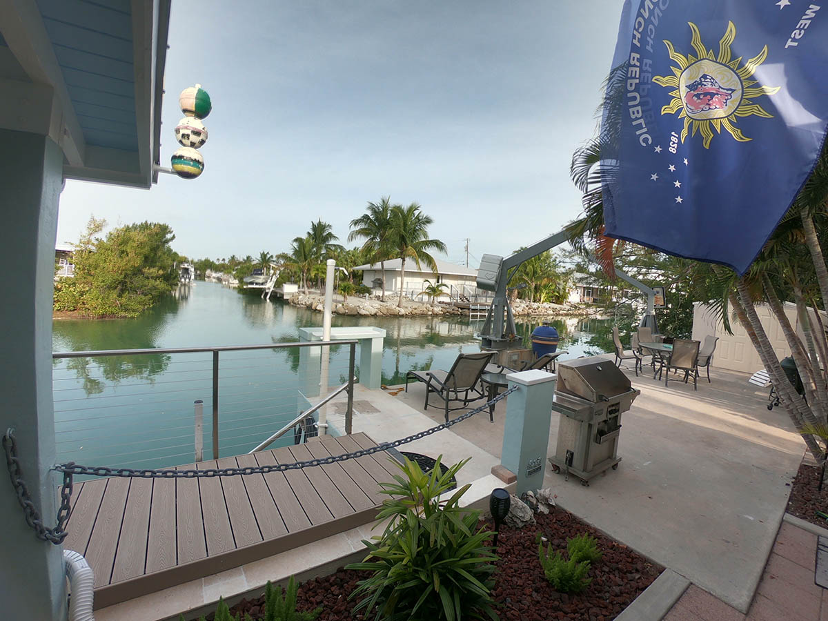Outdoor Deck shown with lounge chairs , table and chairs for 4, stainless gas grill, fish cleaning station,<br>fisherman's rinse-off shower, automatic fish light, and a new umbrella-shaded bar table.